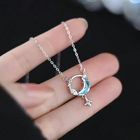 Elegant silver crescent moon pendant necklace on a white background.