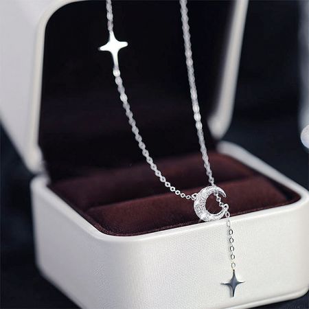 Detailed shot of the crescent moon pendant with a dangling star charm.
