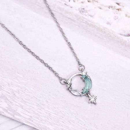 A sterling silver necklace featuring a delicate crescent moon and star charm.