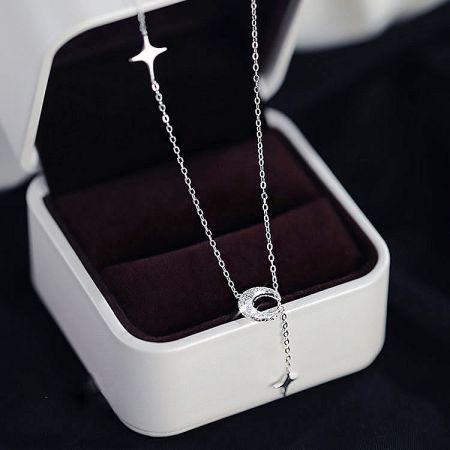 The celestial-themed silver necklace presented in a luxurious white jewelry box.