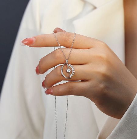 925 Sterling Silver Paved Moon Star Necklace - A detailed view of the 925 Sterling Silver Paved Moon Star Necklace, showcasing the delicate silver chain and the sparkling cubic zirconia-paved crescent moon and star pendant.