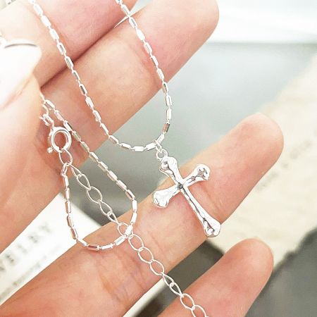 Close-up view of the 925 sterling silver cross pendant, highlighting its craftsmanship and polished finish.