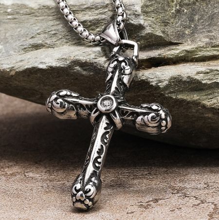 A close-up of the decorative silver cross pendant, highlighting its polished finish and design details.