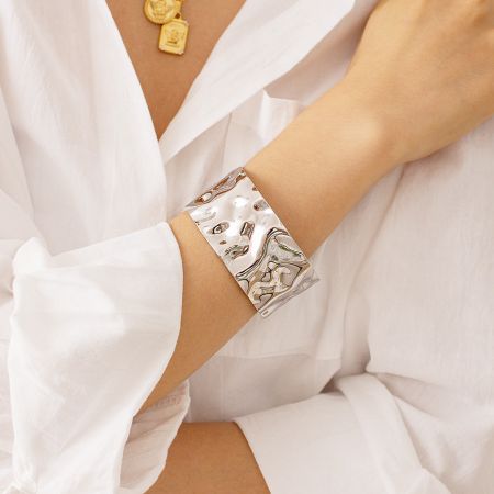 Close-up detail of the intricate marbled and hammered design on the silver cuff bracelet.