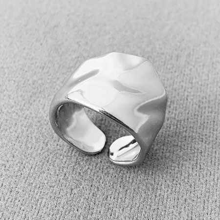 Close-up of a silver irregularly hammered wide band open ring.