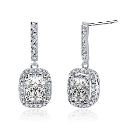 Angled shot of the silver dangle earrings, highlighting the brilliant emerald-cut CZ and surrounding halo of smaller stones.