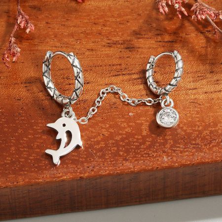 Detailed view of the sterling silver dolphin charm earring with a sparkling gemstone.