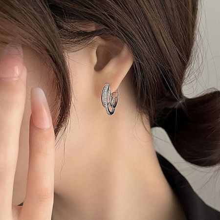 Close-up view of a silver double hoop earring showcasing the intricate placement of small crystals on the inner hoop.