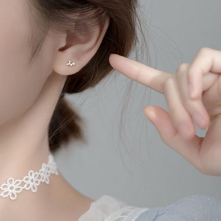 Close-up view of a silver 925 tiny zircon flower stud earring showcasing its intricate details.