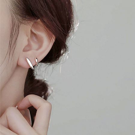 Detailed close-up of a sterling silver wrap cuff stud earring on a white background.