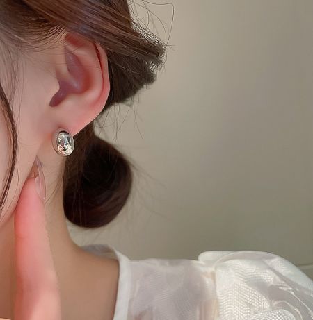 Close-up view of the 925 sterling silver moon stud earring with a sparkling clear gemstone, worn to show scale and detail.