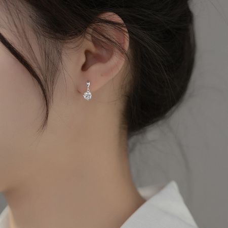 Close-up view of a single sterling silver drop earring with a brilliant-cut cubic zirconia.