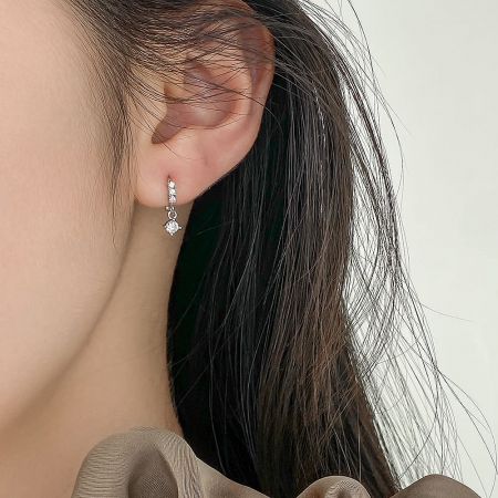 Detailed view of a single sterling silver earring with multiple small inlaid stones, highlighting the craftsmanship.