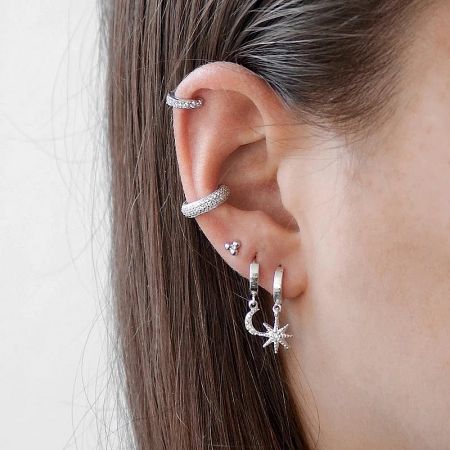 A collection of the five sterling silver zircon ear cuffs, including star and moon charm designs.