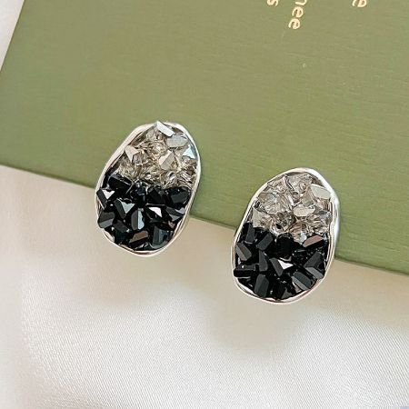Top-down view of the oval earrings highlighting the clear and black gemstone combination.