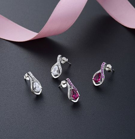 A display of the sterling silver tear drop earrings, showcasing both the ruby pink and clear cubic zirconia color options available.