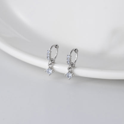 The set of sterling silver zirconia earrings elegantly displayed on a white ceramic plate.