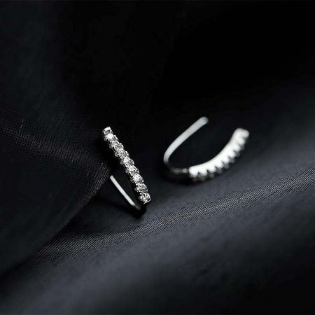 Close-up of the sterling silver hook earrings showcasing the brilliant cubic zirconia stones on a black fabric background.