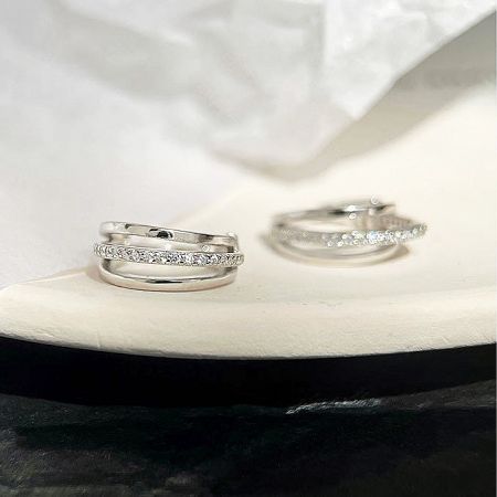 A display of two different pairs of sterling silver earrings featuring detailed gemstone settings.