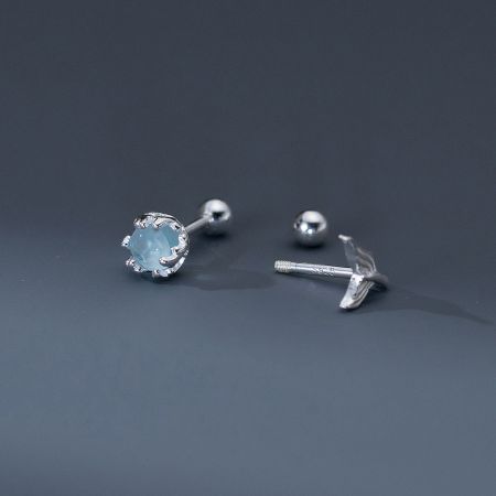 Close-up of the asymmetrical earring components: a light blue gemstone stud and the secure spiral screw-back piece.