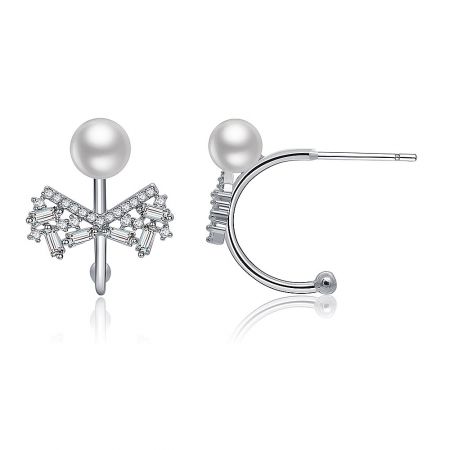 Close-up of the Hook Pearl CZ Bow Earring on a reflective surface.