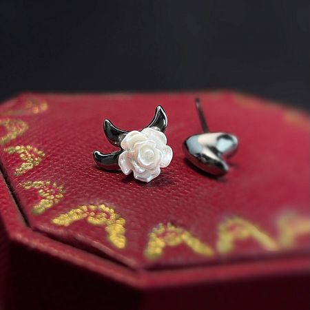 Overhead view of the earring pair, displaying the white rose detail and the plain backing.