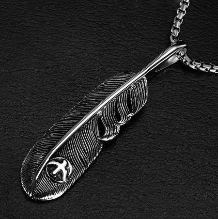 Close-up detail of the silver feather pendant, highlighting the intricate textures.