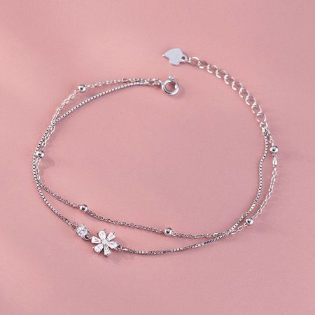Detailed view of the silver double-layer bracelet showcasing the intricate flower charm.