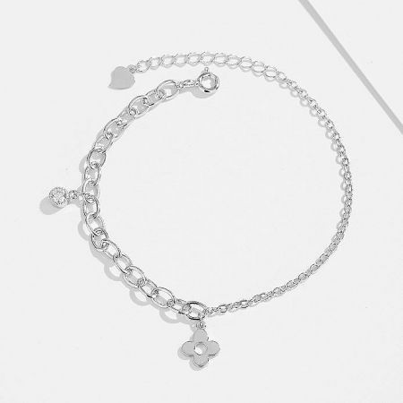 Close-up of a sterling silver chain bracelet with a flower charm.