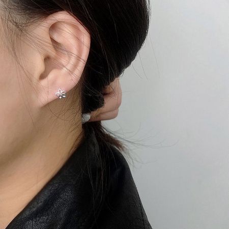 Model wearing the 925 sterling silver flower huggie earring.