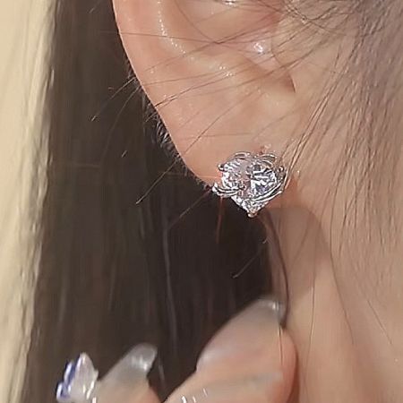 A model wearing the silver hug heart zircon stud earring, showing its scale and sparkle.