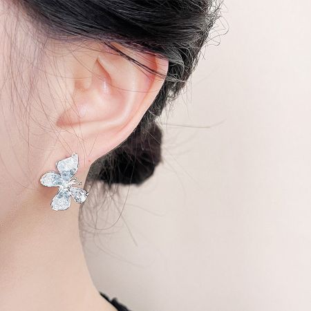 A model wearing one of the delicate crystal butterfly stud earrings to showcase its size and style.