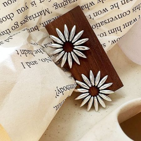 A pair of detailed 925 sterling silver hollow daisy flower stud earrings.