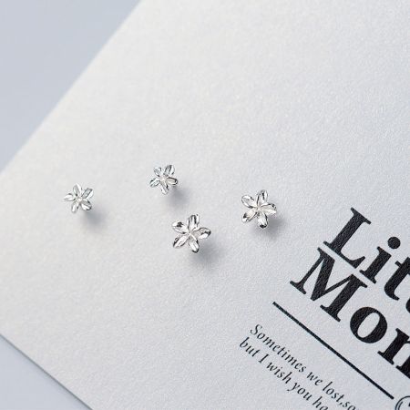 Close-up of the S925 silver flower stud earrings on a white surface.