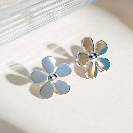 A pair of silver daisy stud earrings against a clean white background, ideal for product listings.