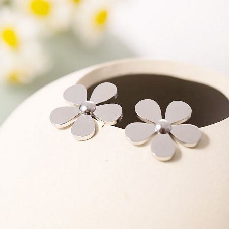 Close-up of the silver daisy flower stud earrings, highlighting the polished stainless steel finish.