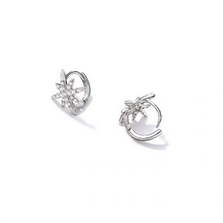 A pair of silver starburst flower-shaped earrings with clear gemstones.