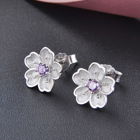 Another perspective of the silver flower earrings with purple gemstones.