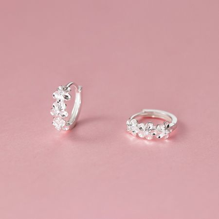 A pair of 925 sterling silver flower-shaped hoop earrings against a white background.