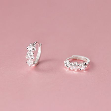 Another angle of the silver flower hoop earrings, highlighting their elegant circular shape and floral adornments.