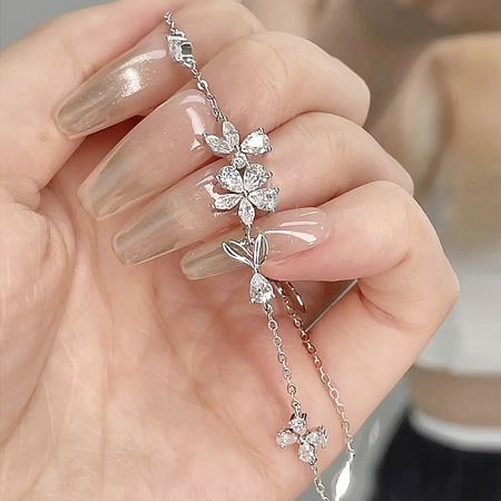 Detailed view of the sakura flower pendant on the sterling silver bracelet.