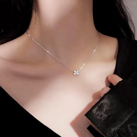 Model showcasing the elegant silver four-leaf clover necklace.