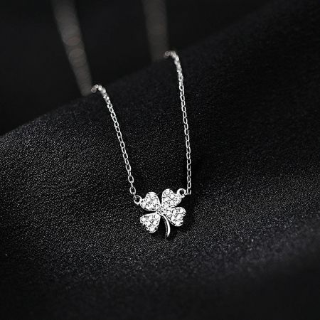Close-up of the silver four-leaf clover pendant with sparkling zircon details.