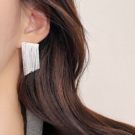 Detailed close-up shot of a single silver fringe earring, highlighting its craftsmanship.