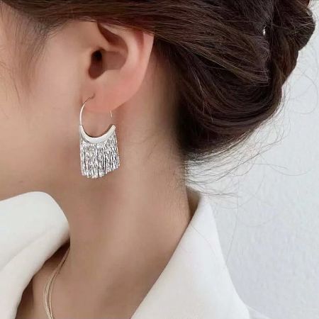 Model wearing the 925 sterling silver tassel earrings to showcase their length and movement.