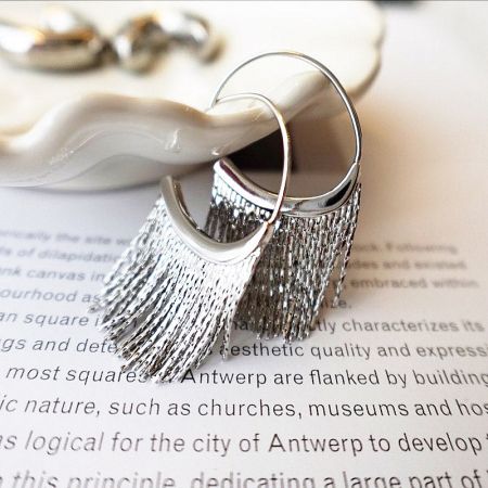 A pair of sterling silver earrings with a full, shimmering fringe design.