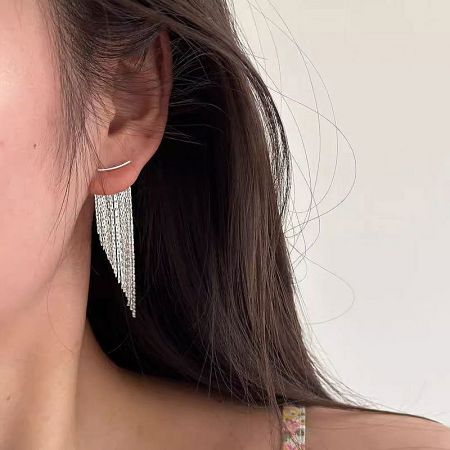 Side profile of a model wearing the silver fringed dangling earrings.