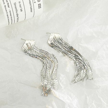 Close-up detail of the silver tassel earring, highlighting the intricate wavy and fringed sterling silver chains.