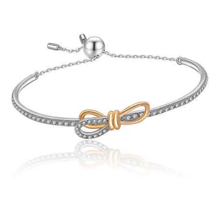 Detailed view of the Tied Ribbon Bow Bangle showcasing the intricate pave-set cubic zirconia on the silver and gold bow design.
