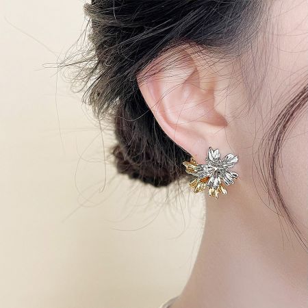 Close-up view of the two-tone leaf-flower stud earring worn by a model, highlighting the intricate design.